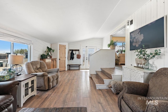 living room with wood walls, lofted ceiling, and hardwood / wood-style flooring