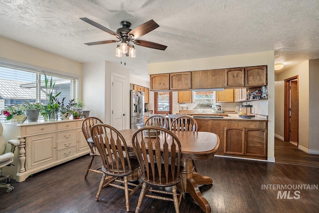 dining room with a wealth of natural light, dark hardwood / wood-style flooring, ceiling fan, and a textured ceiling