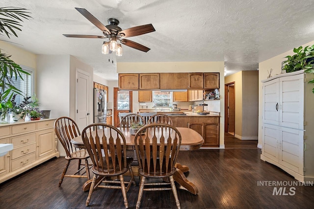 dining area featuring a textured ceiling, dark wood-type flooring, and a wealth of natural light