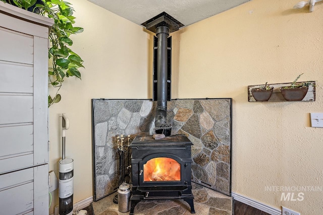 room details featuring a wood stove and a textured ceiling