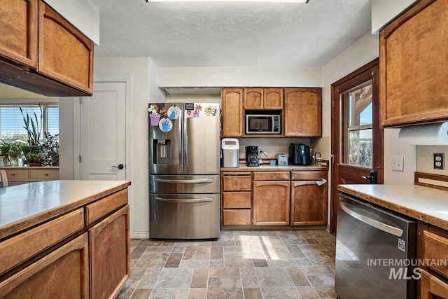 kitchen with a textured ceiling and stainless steel appliances