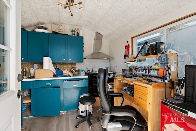 office space featuring a workshop area, wood-type flooring, and lofted ceiling