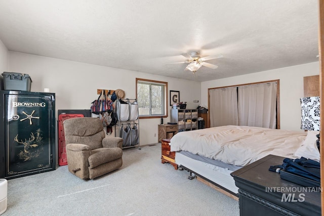 carpeted bedroom with a textured ceiling, a closet, and ceiling fan