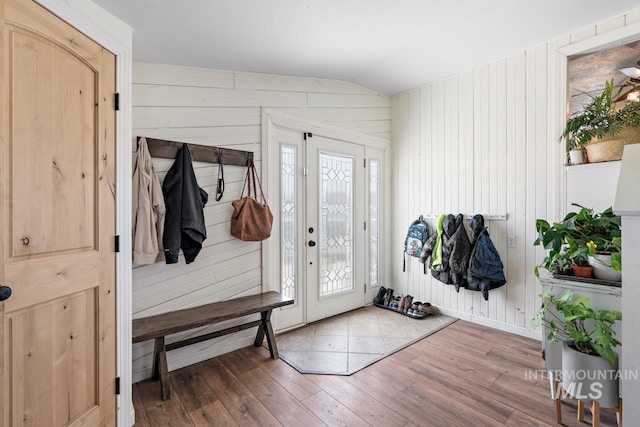 mudroom with wood walls, wood-type flooring, and lofted ceiling