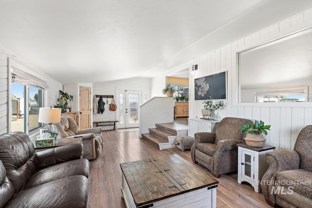 living room with hardwood / wood-style flooring, lofted ceiling, and wood walls