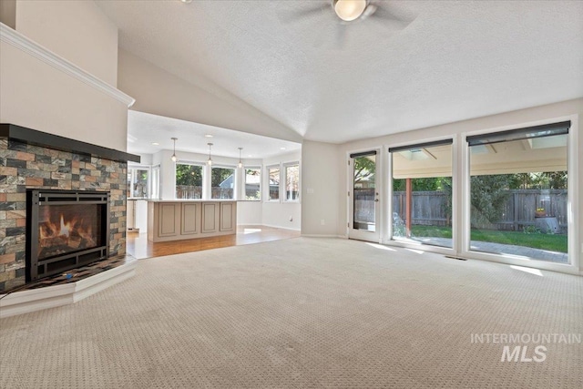 1825 E Seaside Ct, Boise, ID 83706 - unfurnished living room with light carpet, a fireplace, ceiling fan, lofted ceiling, and plenty of natural light