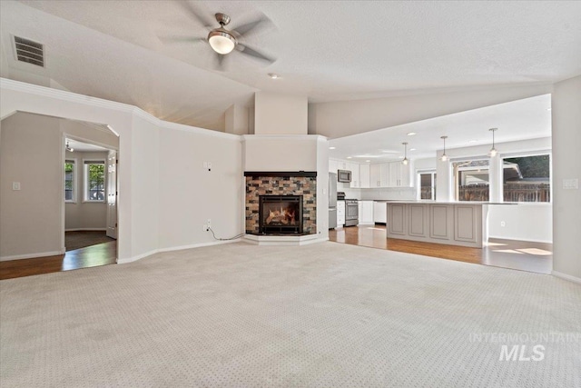 1825 E Seaside Ct, Boise, ID 83706 - unfurnished living room featuring light carpet, lofted ceiling, a fireplace, ceiling fan, and baseboards