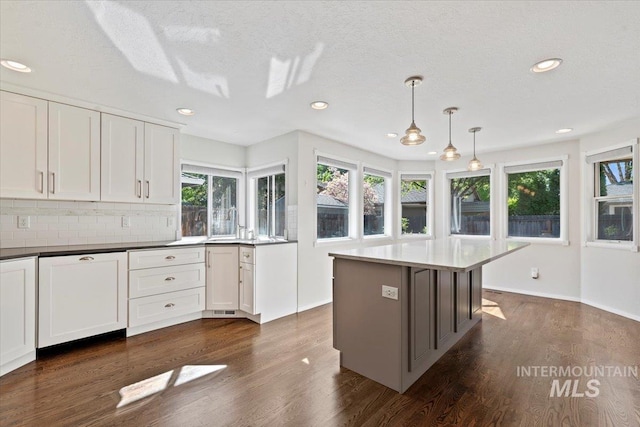 1825 E Seaside Ct, Boise, ID 83706 - kitchen with dark wood-type flooring, white cabinets, backsplash, and recessed lighting