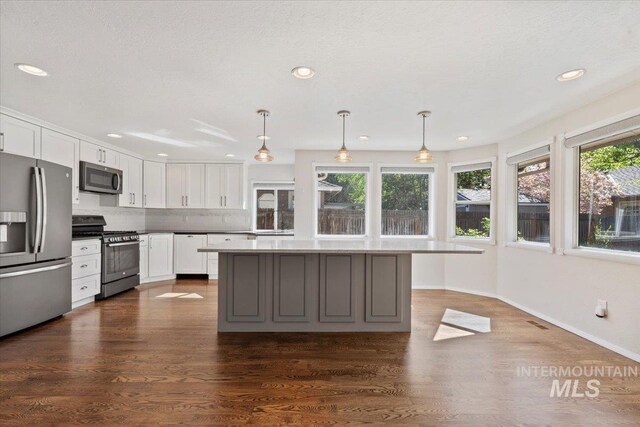 1825 E Seaside Ct, Boise, ID 83706 - kitchen with appliances with stainless steel finishes, white cabinets, baseboards, recessed lighting, and a center island