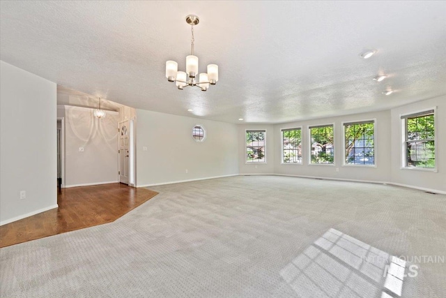 1825 E Seaside Ct, Boise, ID 83706 - unfurnished living room with carpet flooring, a chandelier, a textured ceiling, and baseboards
