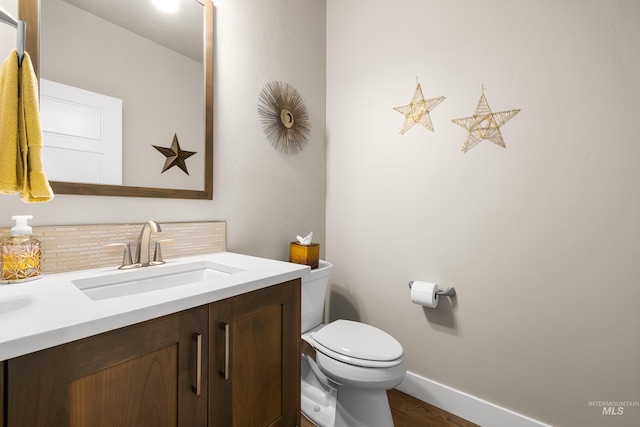 11684 N 23rd Ave, Boise, ID 83714 - bathroom featuring decorative backsplash, toilet, vanity, wood finished floors, and baseboards