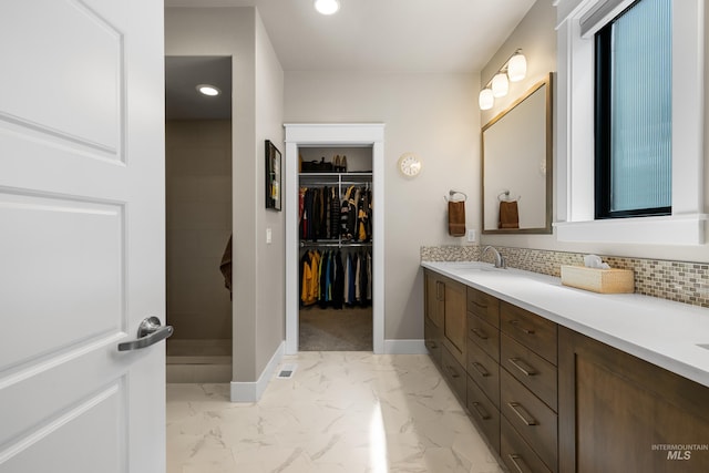 11684 N 23rd Ave, Boise, ID 83714 - bathroom featuring baseboards, double vanity, marble finish floors, a spacious closet, and backsplash