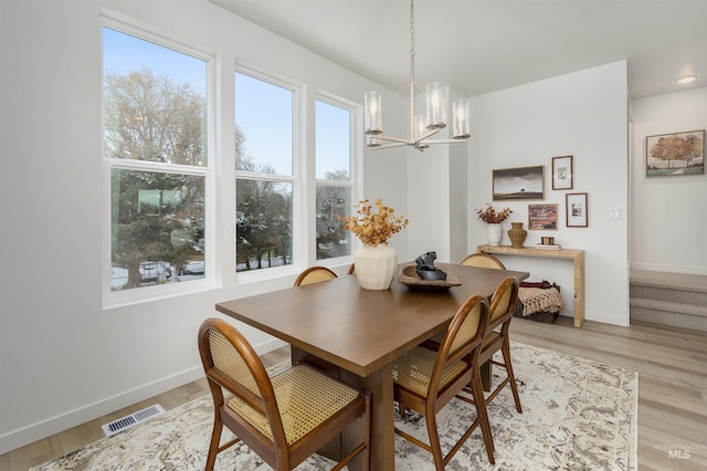 dining space with a chandelier and light hardwood / wood-style flooring