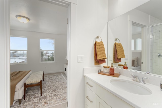 bathroom with vanity, a shower with shower door, and a healthy amount of sunlight