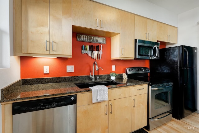 502 S 15th St # 104, Boise, ID 83702 - kitchen featuring light wood finished floors, stainless steel appliances, light brown cabinets, a sink, and dark stone counters