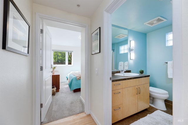 502 S 15th St # 104, Boise, ID 83702 - bathroom with wood finished floors, visible vents, toilet, vanity, and connected bathroom