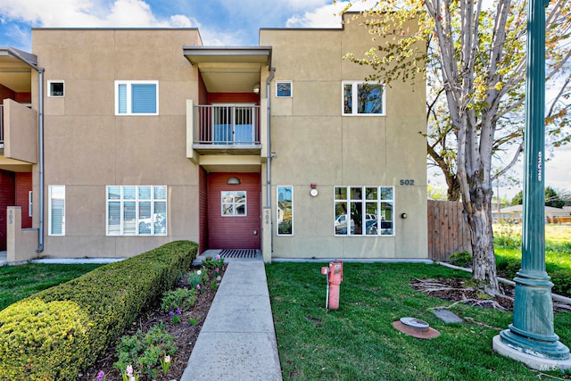 502 S 15th St # 104, Boise, ID 83702 - exterior space with stucco siding, a front lawn, fence, and a balcony