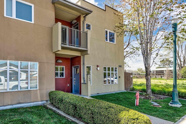 502 S 15th St # 104, Boise, ID 83702 - doorway to property featuring stucco siding, a yard, and a balcony