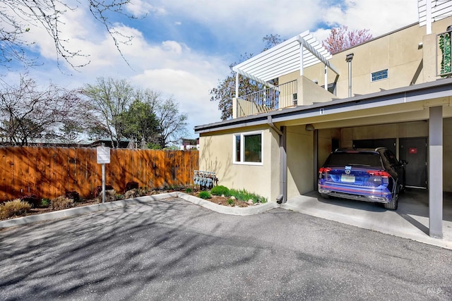 502 S 15th St # 104, Boise, ID 83702 - view of side of home with fence, covered parking, and stucco siding
