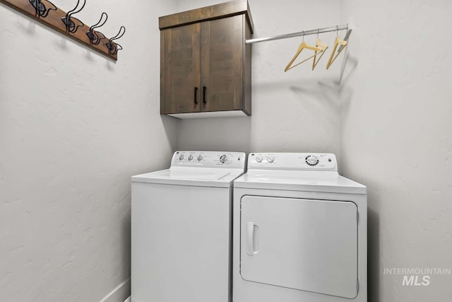 washroom featuring washing machine and clothes dryer and cabinet space