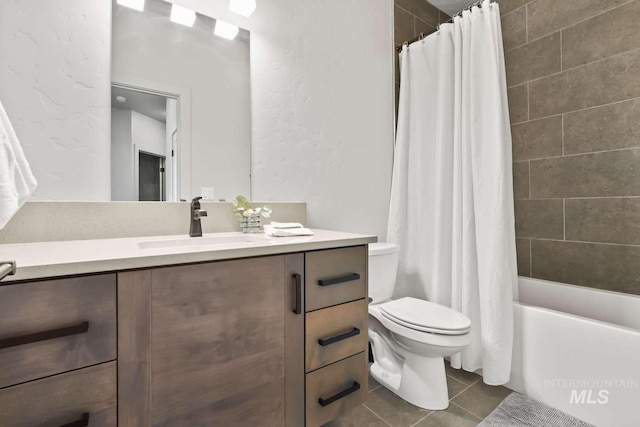 full bath featuring vanity, shower / tub combo, tile patterned floors, toilet, and a textured wall