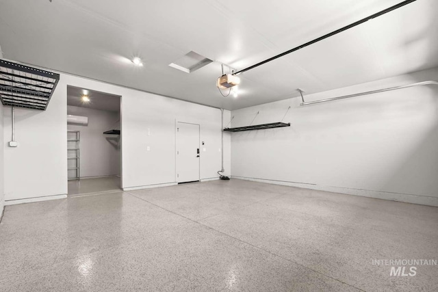 garage featuring a garage door opener and baseboards