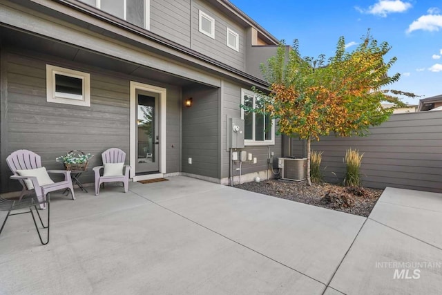 view of patio with cooling unit and fence