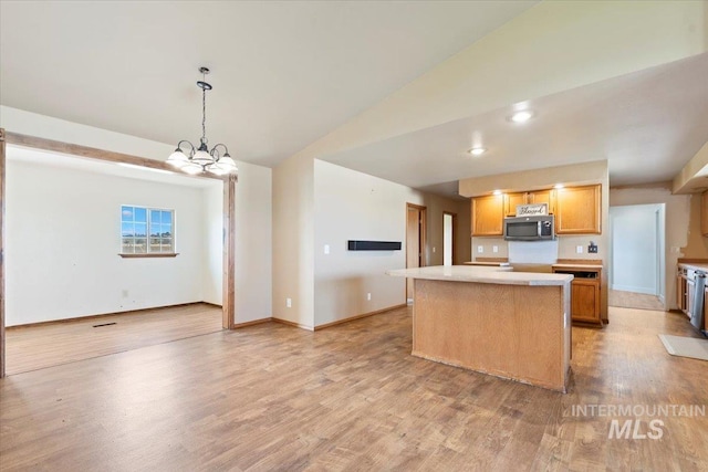 11716 S Emerald Rd, Nampa, ID 83686 - kitchen with stainless steel microwave, a kitchen island, light countertops, light wood-type flooring, and lofted ceiling