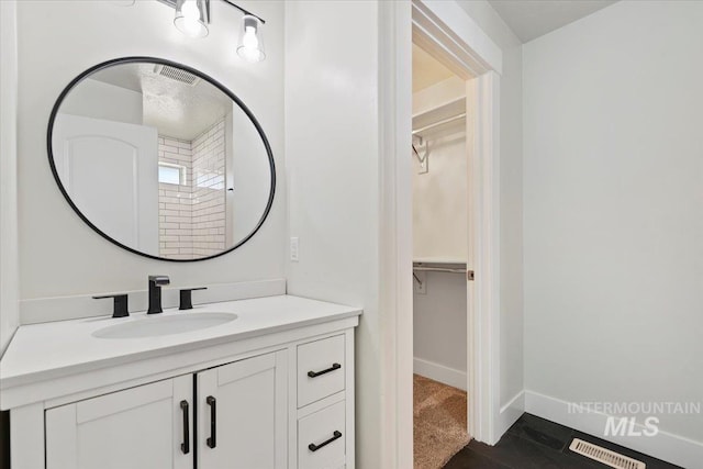 11716 S Emerald Rd, Nampa, ID 83686 - bathroom with vanity, a walk in closet, and baseboards