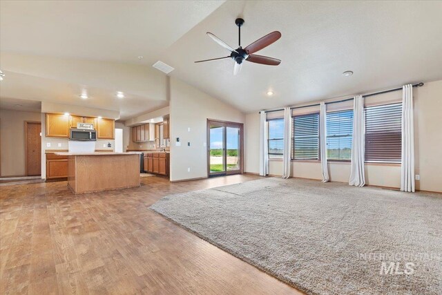 11716 S Emerald Rd, Nampa, ID 83686 - unfurnished living room with lofted ceiling, a ceiling fan, light wood finished floors, and baseboards