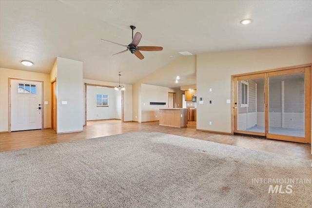 11716 S Emerald Rd, Nampa, ID 83686 - unfurnished living room featuring ceiling fan, lofted ceiling, light colored carpet, baseboards, and a chandelier