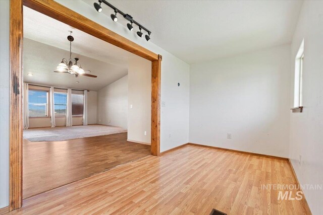 11716 S Emerald Rd, Nampa, ID 83686 - empty room featuring a chandelier, wood finished floors, baseboards, and rail lighting