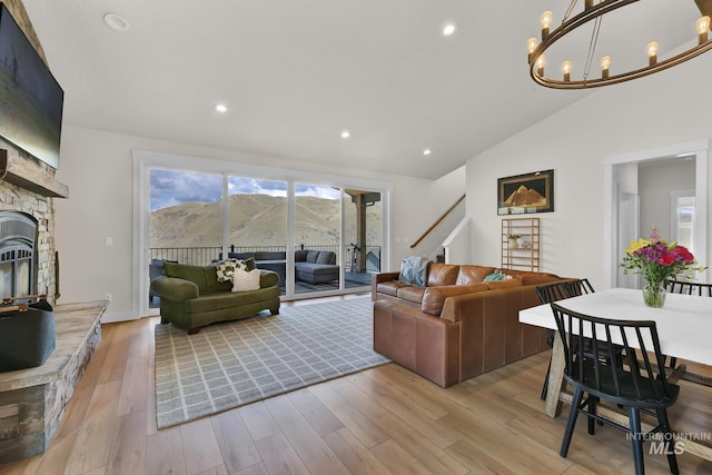 44 Shoemaker Dr, Horseshoe Bend, ID 83629 - living room featuring lofted ceiling, light wood-style flooring, a chandelier, a stone fireplace, and recessed lighting