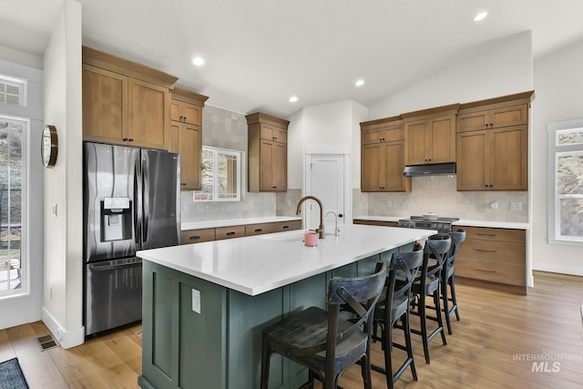 44 Shoemaker Dr, Horseshoe Bend, ID 83629 - kitchen featuring stainless steel fridge, a sink, light wood-type flooring, an island with sink, and light countertops