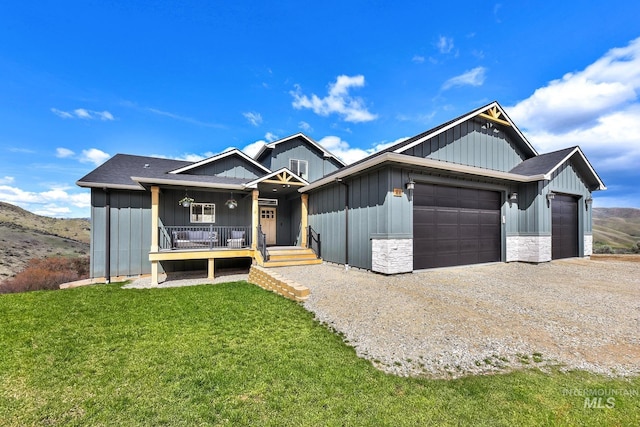 44 Shoemaker Dr, Horseshoe Bend, ID 83629 - view of front facade with an attached garage, a porch, a front yard, gravel driveway, and board and batten siding