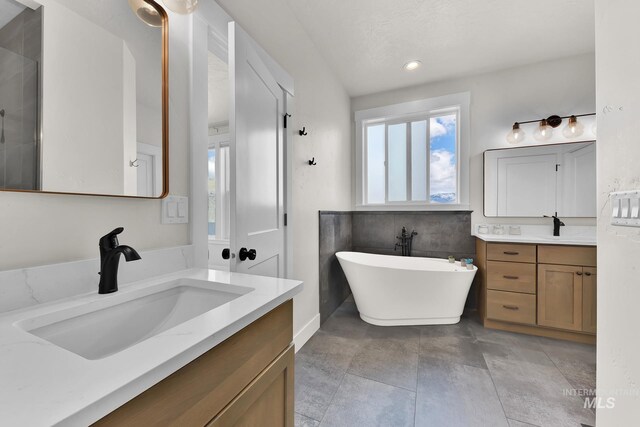 44 Shoemaker Dr, Horseshoe Bend, ID 83629 - full bathroom with two vanities, a freestanding tub, and recessed lighting