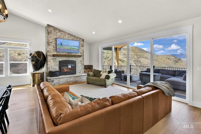 44 Shoemaker Dr, Horseshoe Bend, ID 83629 - living area featuring lofted ceiling, wood finished floors, a stone fireplace, recessed lighting, and baseboards