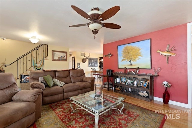 living room featuring ceiling fan and hardwood / wood-style flooring