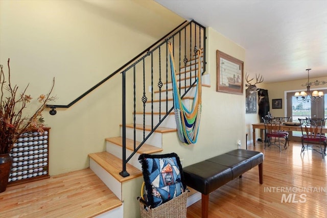 staircase featuring a chandelier and hardwood / wood-style flooring