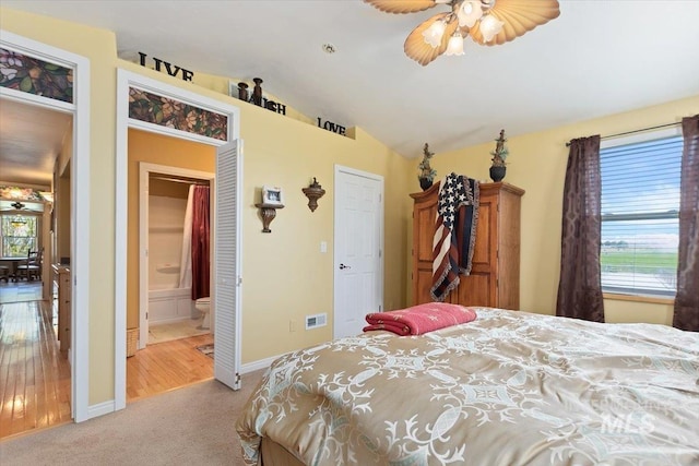 bedroom featuring wood-type flooring, multiple windows, vaulted ceiling, and ceiling fan