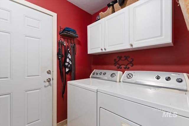 laundry room with washer and dryer and cabinets