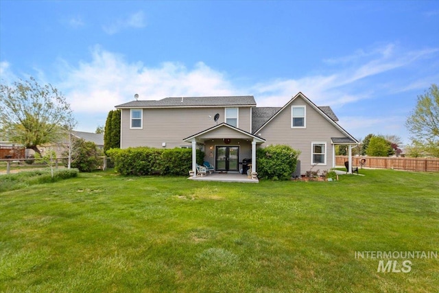 rear view of house featuring a patio area and a lawn