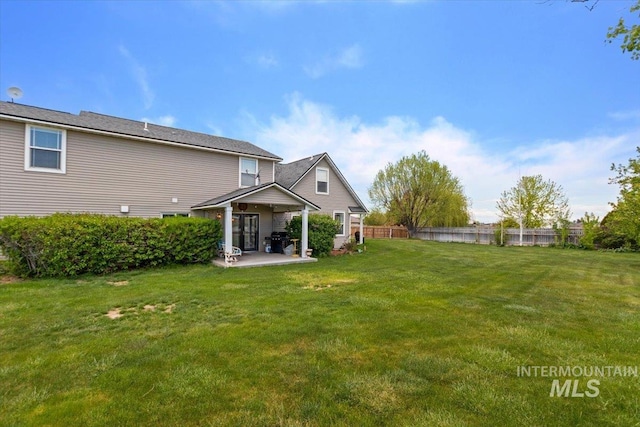 rear view of house with a patio area and a lawn