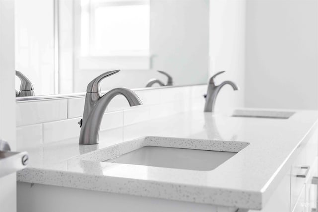 interior details featuring a sink and decorative backsplash