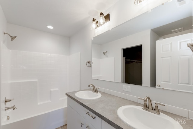 bathroom featuring shower / bathing tub combination, double vanity, visible vents, and a sink