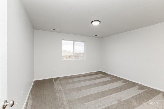 spare room with visible vents, baseboards, and carpet floors