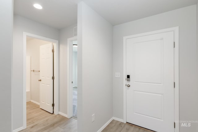 foyer featuring light wood-style flooring, visible vents, baseboards, and recessed lighting