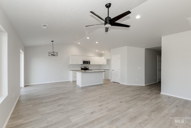 unfurnished living room with vaulted ceiling, light wood-style flooring, a ceiling fan, and baseboards