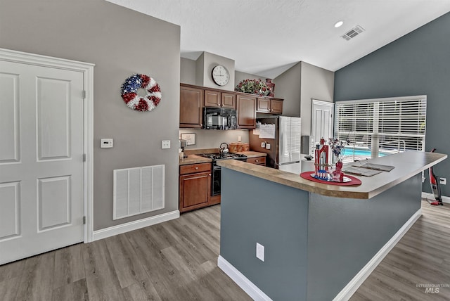 2814 N Cloverdale, Boise, ID 83713 - kitchen featuring black microwave, freestanding refrigerator, gas stove, light wood-style flooring, and high vaulted ceiling
