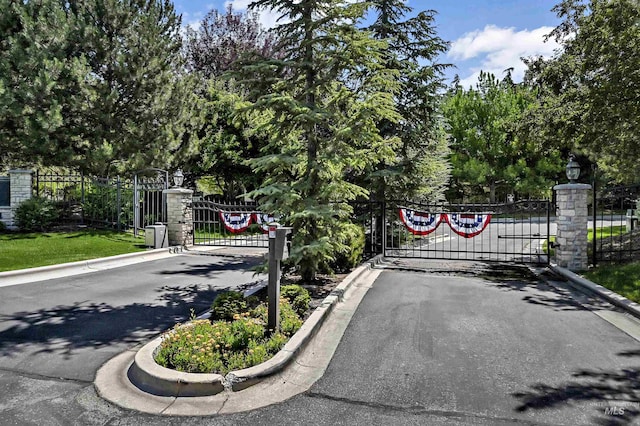 2814 N Cloverdale, Boise, ID 83713 - view of asphalt street featuring a gate, curbs, a gated entry, and street lighting